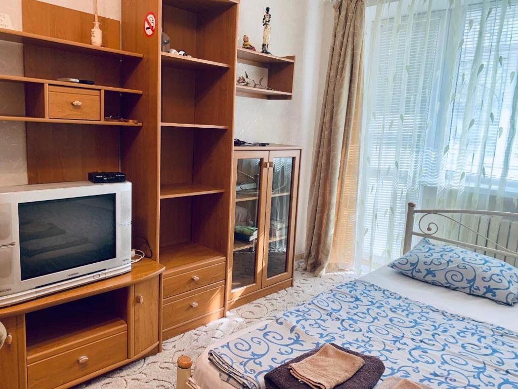 um quarto com uma cama, uma televisão e prateleiras em Апартаменти в центрі на набережній Дніпра Шпиталь Apartment in downtown em Dnipro