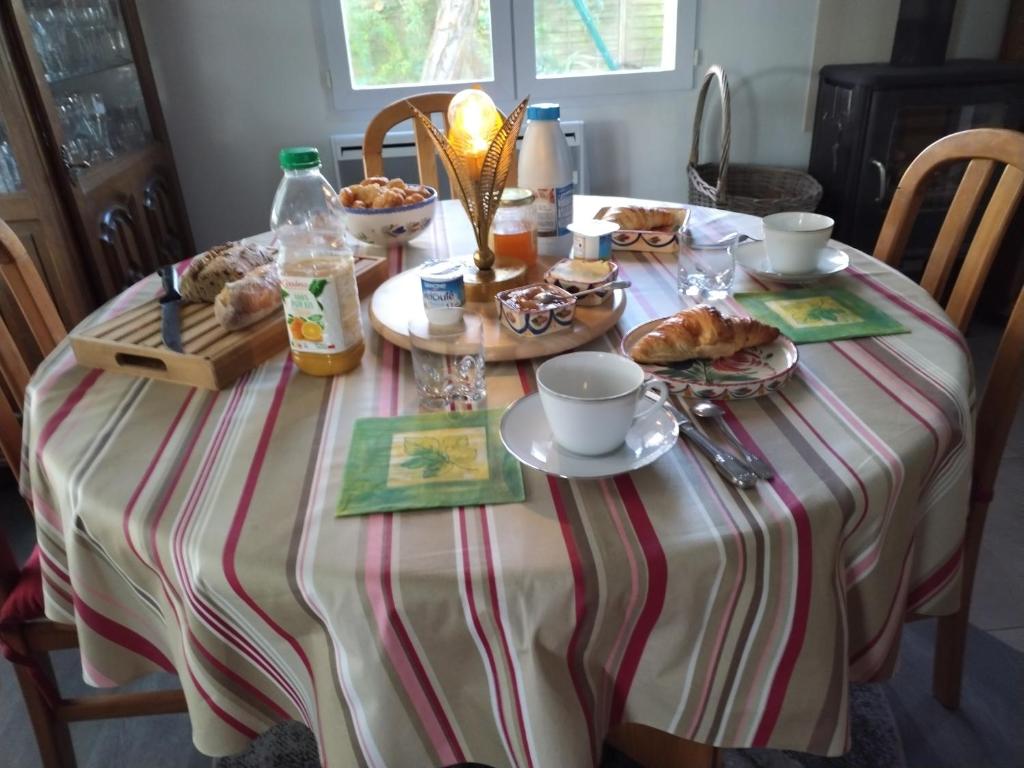 einem Tisch mit einem gestreiften Tischtuch mit Nahrung darauf in der Unterkunft TY BIHAN in La Bernerie-en-Retz