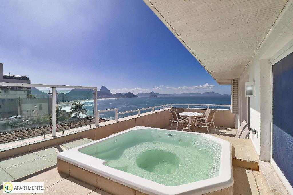 a bath tub on a balcony with a view of the ocean at Beautiful 4BR duplex penthouse in Rio de Janeiro