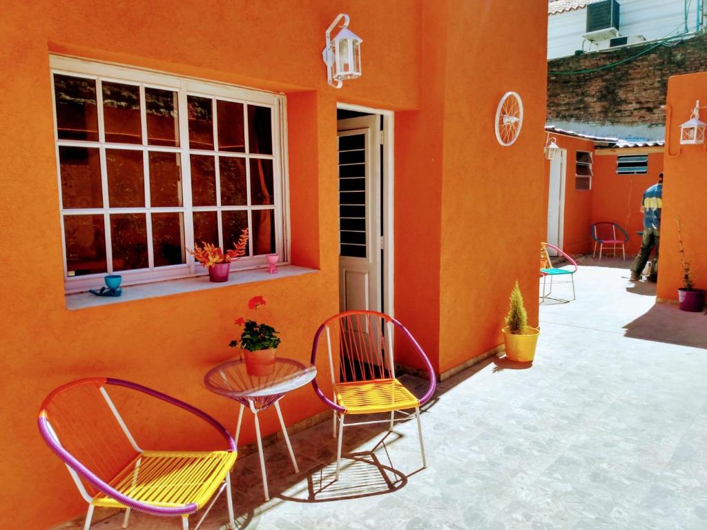 un patio con sillas, una mesa y una ventana en CASA REINA Apartamentos en Buenos Aires