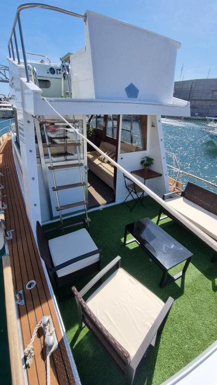 a balcony on a yacht with a table and chairs at Charming boat house in Barcelona with big terrace and solarium in Barcelona
