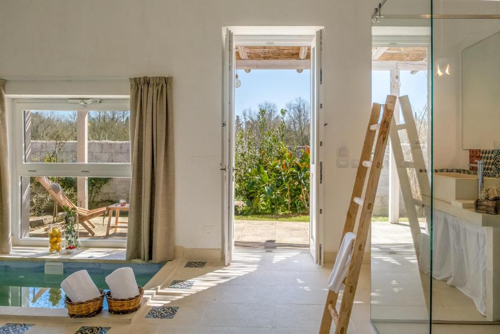 a room with a ladder and a glass door at Masseria Rauccio in Torre dell'Orso