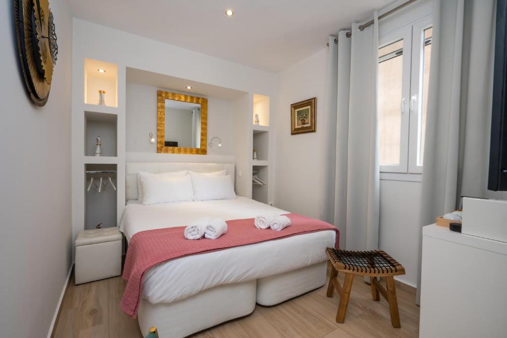 a white bedroom with a bed with towels on it at Dema's Luxury Suites in Athens