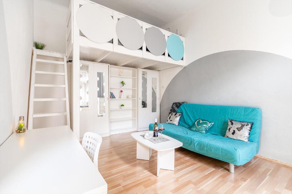 uma sala de estar com um sofá azul e uma mesa em Sunny Dots Apartment em Budapeste