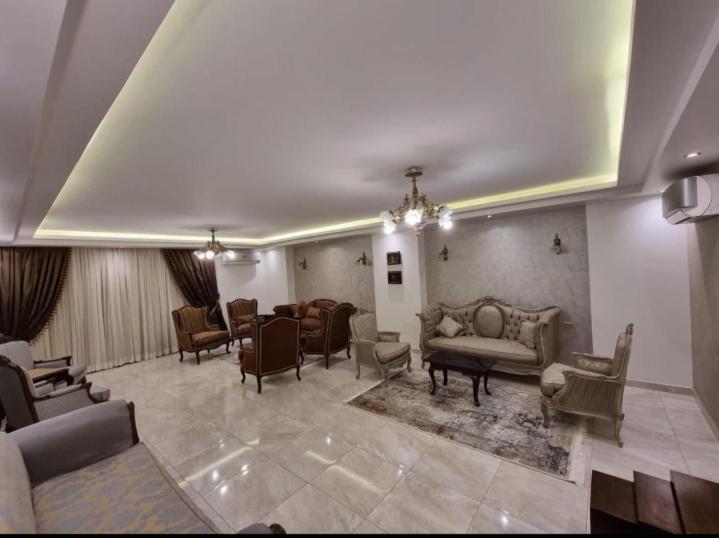 un ampio soggiorno con divani e sedie di شقة مفروشة فخمه لهواة الذوق الرفيع فقط a Il Cairo