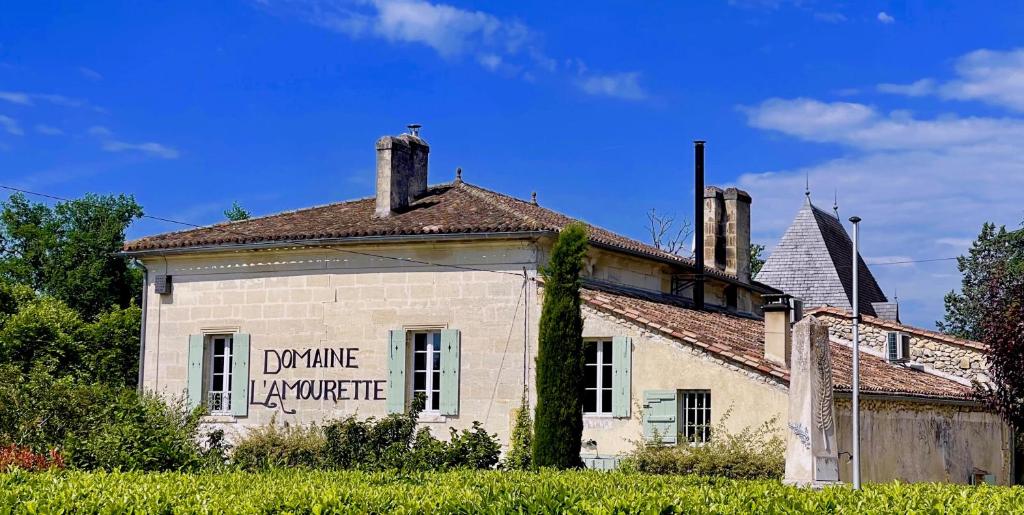 Una casa vieja con un cartel en el costado. en Domaine L'Amourette, en Tizac-de-Curton