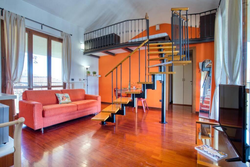 uma sala de estar com um sofá e uma escada em espiral em CaseOspitali - Casa Niden il tuo nido a Cernusco vicino alla metro 2pax em Cernusco sul Naviglio