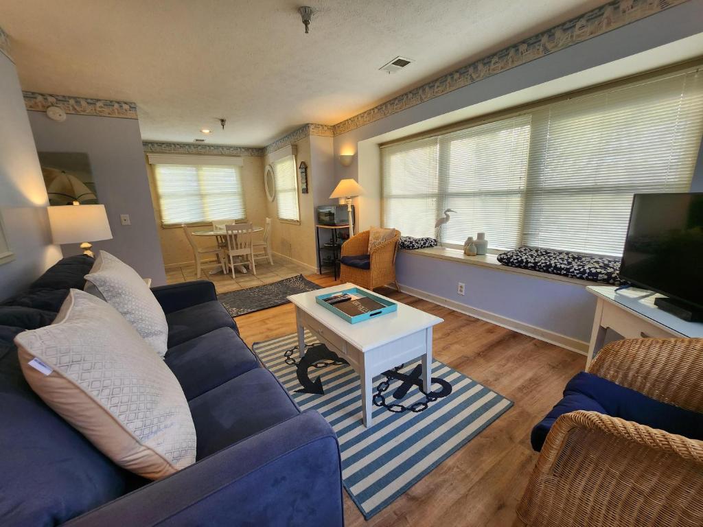 特拉弗斯城的住宿－North Shore Inn TC 300，客厅配有蓝色的沙发和桌子