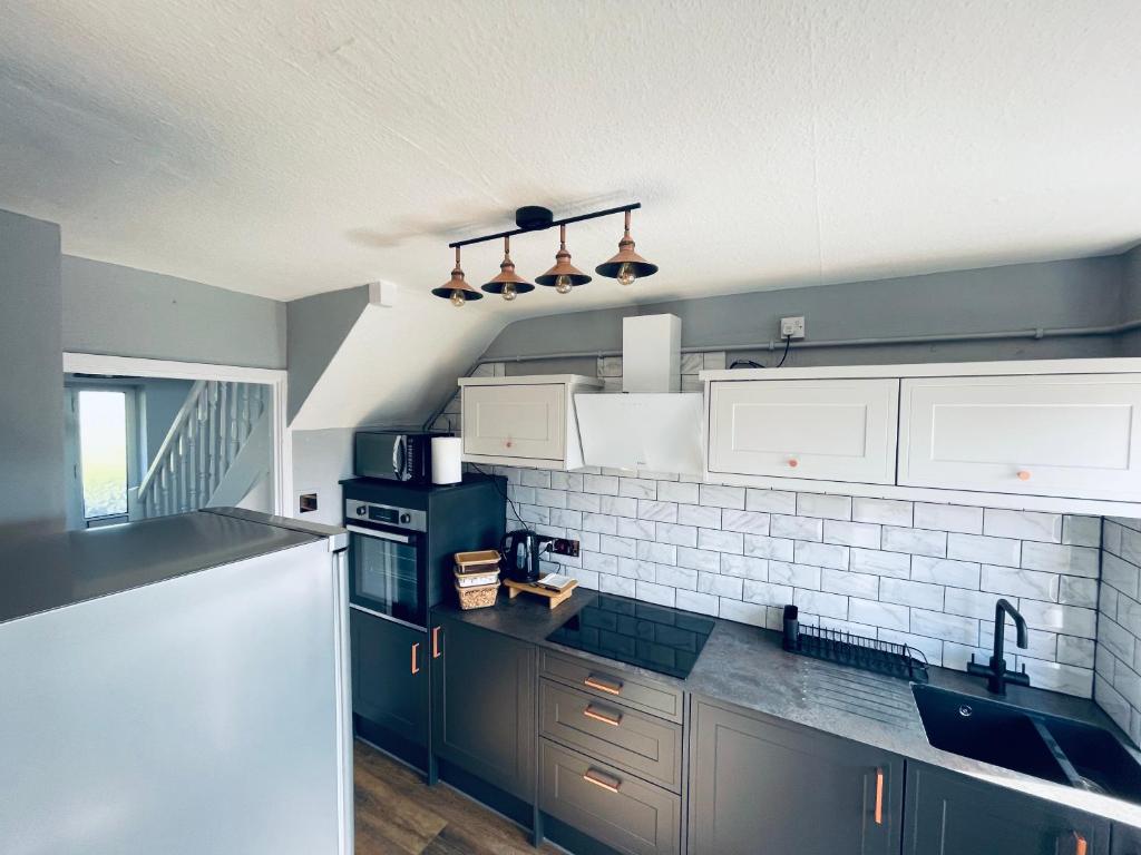 a kitchen with white cabinets and a white refrigerator at Family room, Shared House in Bristol