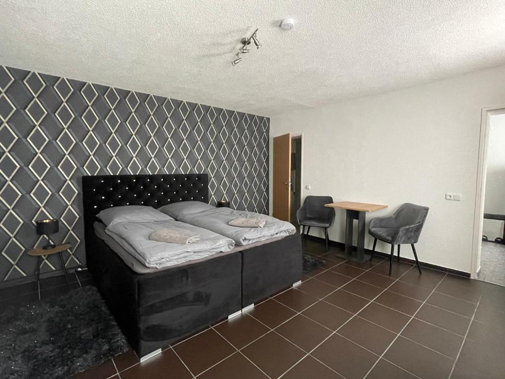 Schlafzimmer mit einem Bett, einem Tisch und Stühlen in der Unterkunft Ferienwohnung - Gästewohnung in Forst(Lausitz) in Forst