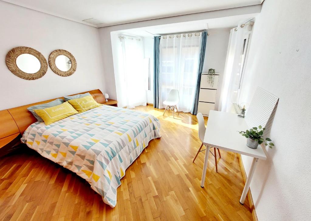 sypialnia z łóżkiem, stołem i lustrem w obiekcie Apartamento céntrico y luminoso cerca de la playa. w mieście Castellón de la Plana