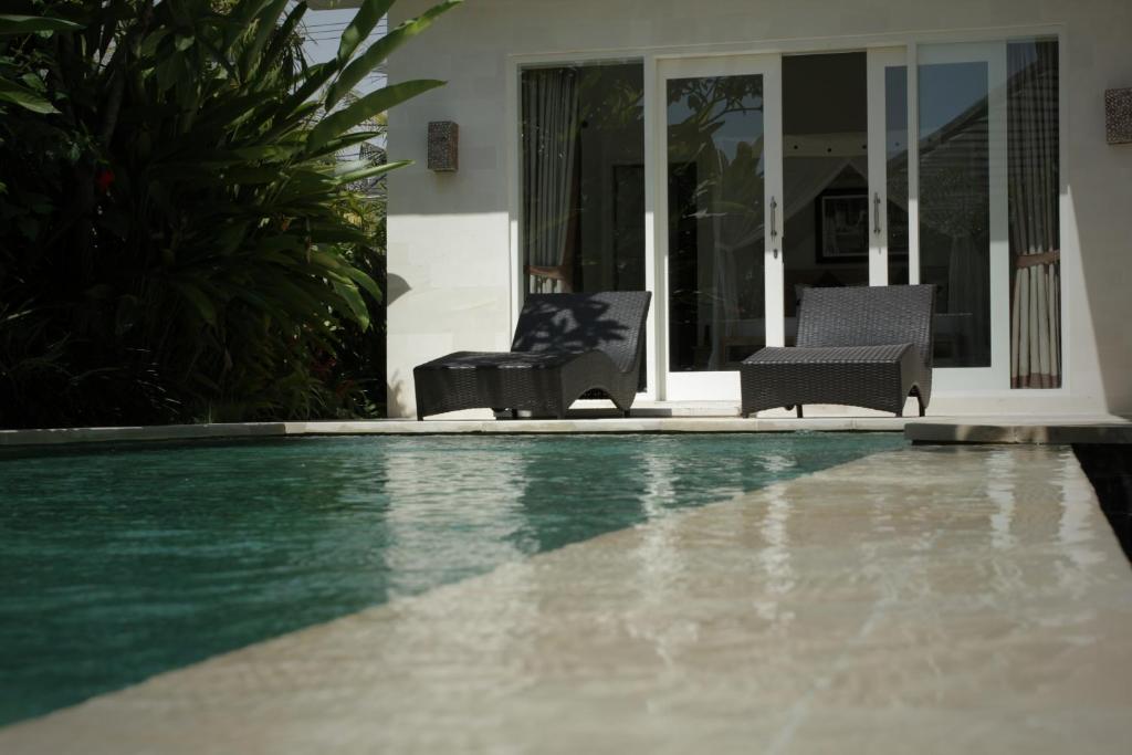 乌布珠玛酒店的游泳池旁的两把椅子