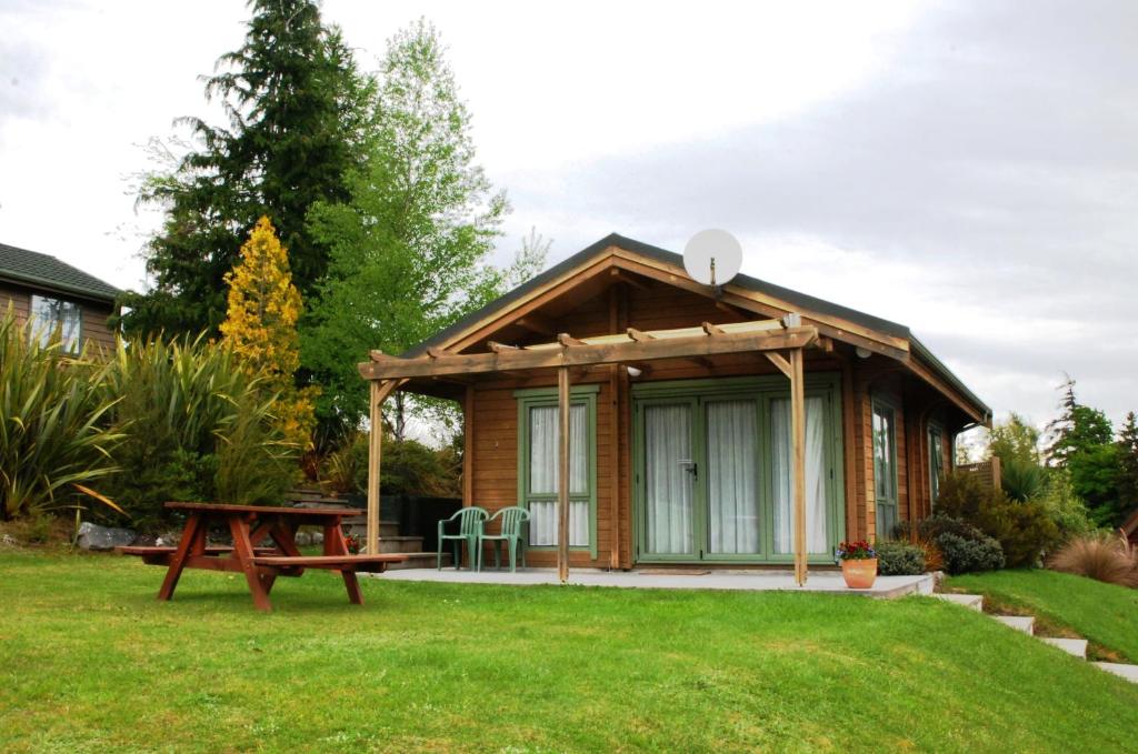 a small cabin with a picnic table in a yard at The Chalets Motel in Hanmer Springs