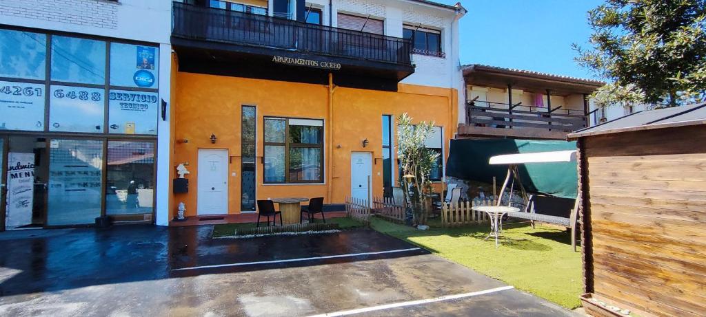 an orange and white building with a bench in a yard at Apartamento Premium Relax D in Cicero