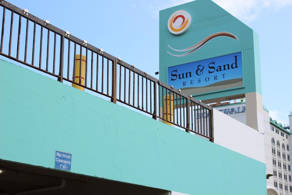 ein Schild für das Sonnen- und Sandresort auf einem Gebäude in der Unterkunft Sun & Sand Resort Oceanfront Suites in Virginia Beach