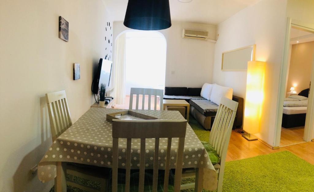 eine Küche und ein Wohnzimmer mit einem Tisch und einem Sofa in der Unterkunft Mario Apartment in Budva