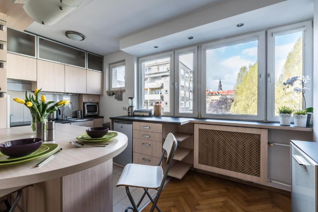a kitchen with white cabinets and a large window at Komfort w samym centrum in Wrocław