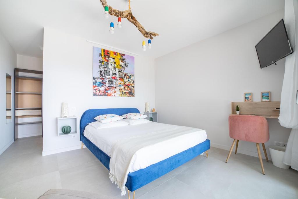 阿雅克肖的住宿－CASA LC chambre1 vue Mer Jacuzzi，白色卧室配有蓝色的床和电视