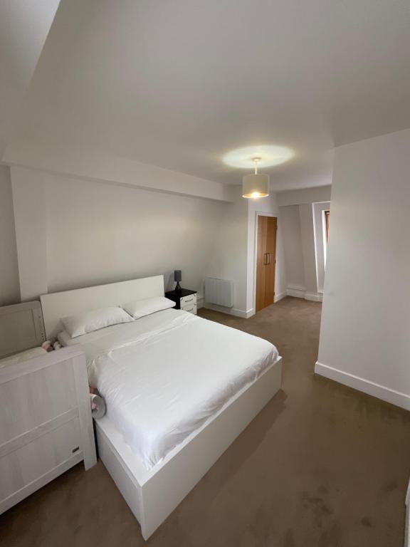 a white bedroom with a large white bed in it at Clarendon Flat in Watford