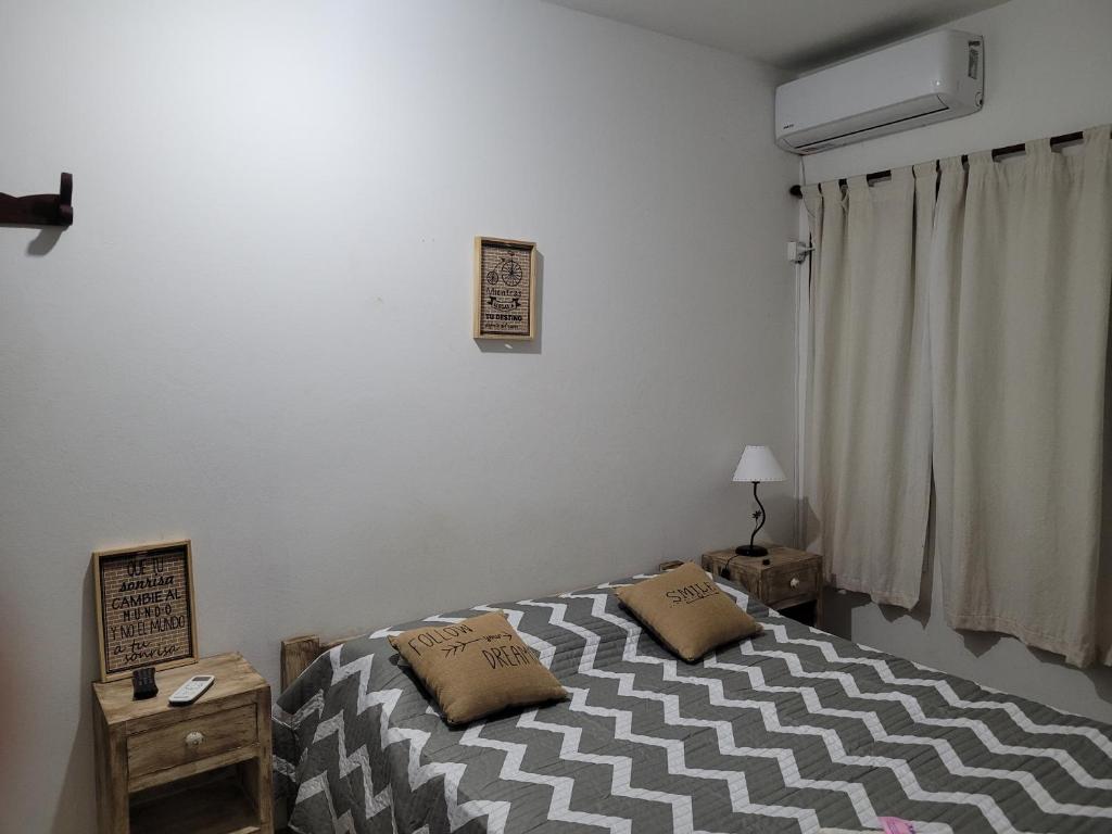 1 dormitorio con 1 cama con 2 almohadas en Depto Céntrico II en Corrientes