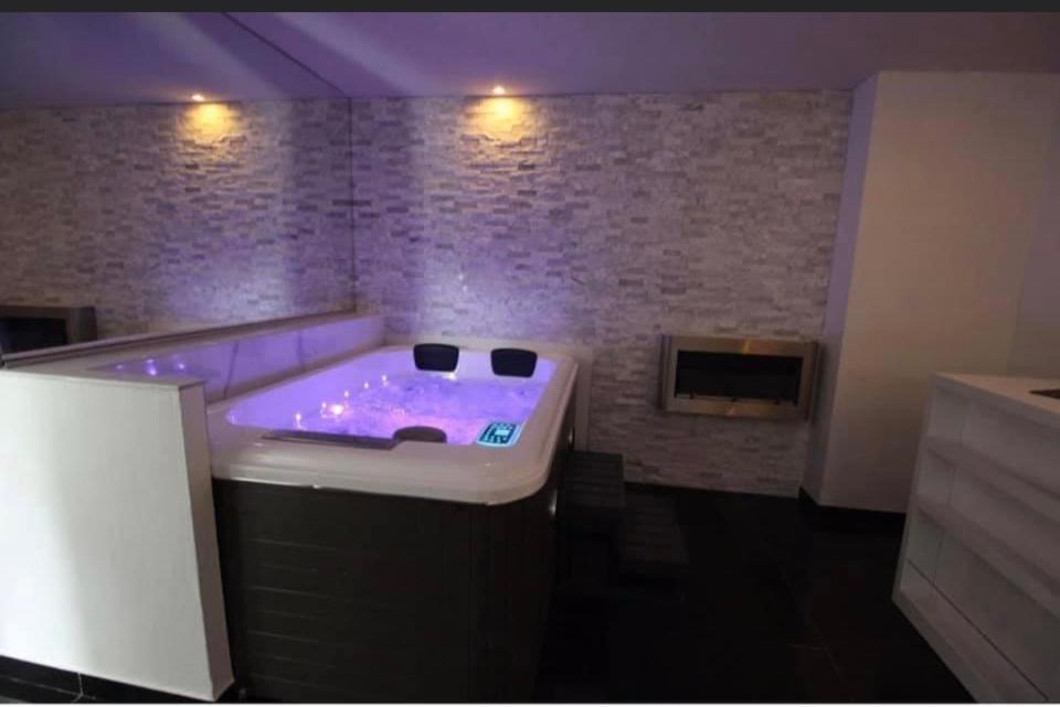 ein lila Zimmer mit einer Badewanne und einem Kamin in der Unterkunft Cocon de douceur 
