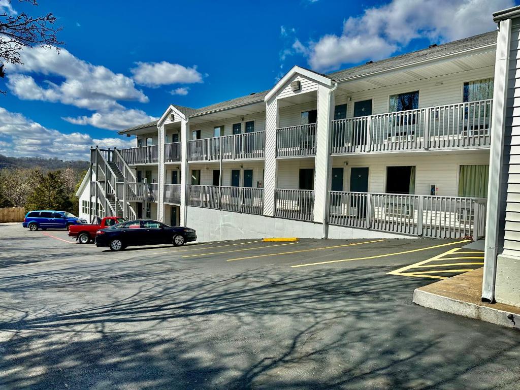 un gran edificio blanco con coches estacionados frente a él en Celebrity Inn, en Branson