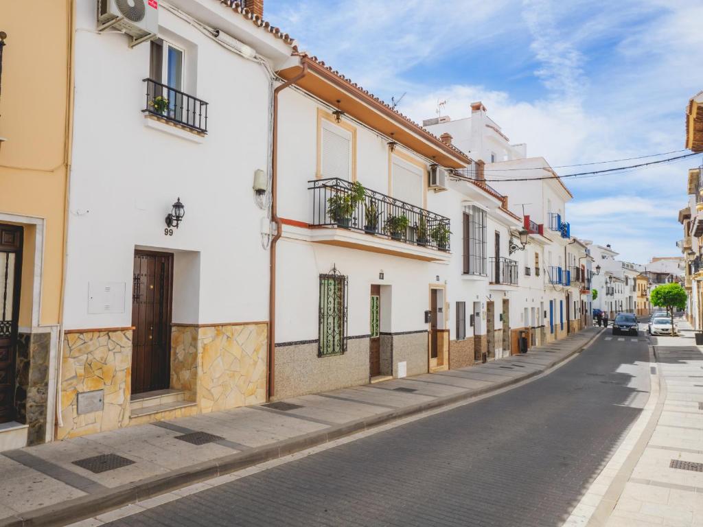 een straat met witte gebouwen op een geplaveide weg bij Cubo's Dreams Alhaurin Room 4 in Alhaurín el Grande