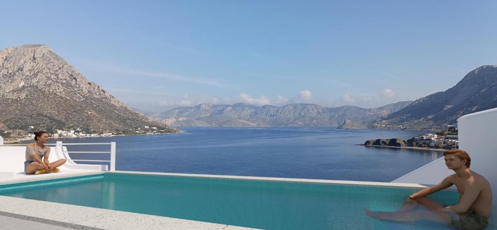 two men sitting next to a swimming pool overlooking the water at Shape-Infinity in Kalymnos