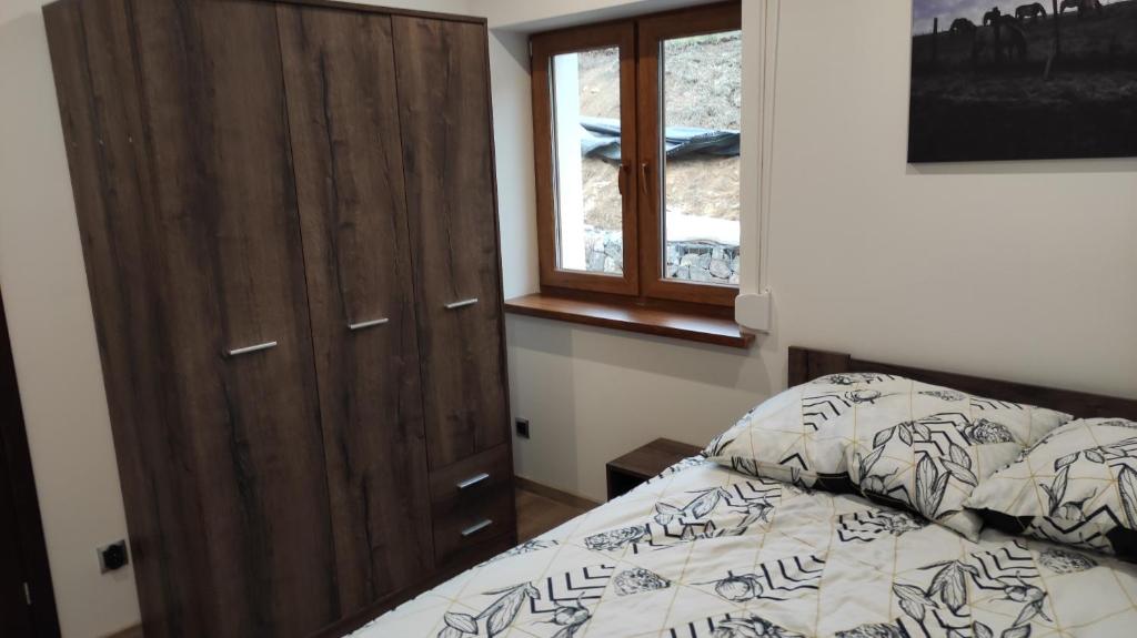 ein Schlafzimmer mit einem Bett und einem Holzschrank in der Unterkunft Apartamenty Klangor in Mrągowo