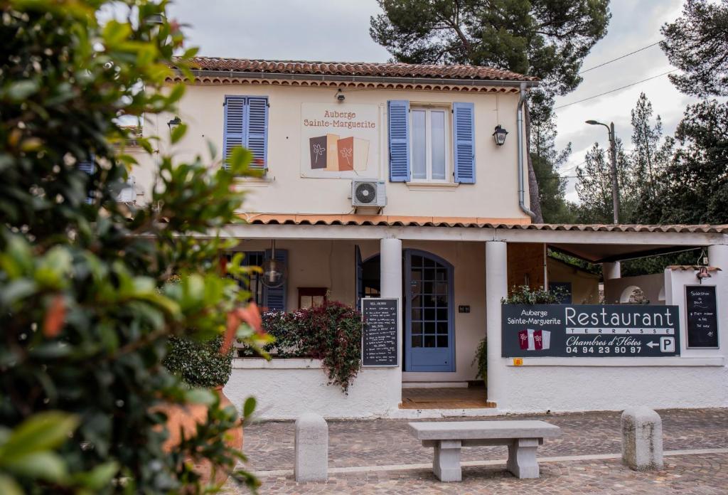 un bâtiment avec un banc devant lui dans l'établissement Auberge Sainte Marguerite, à La Garde