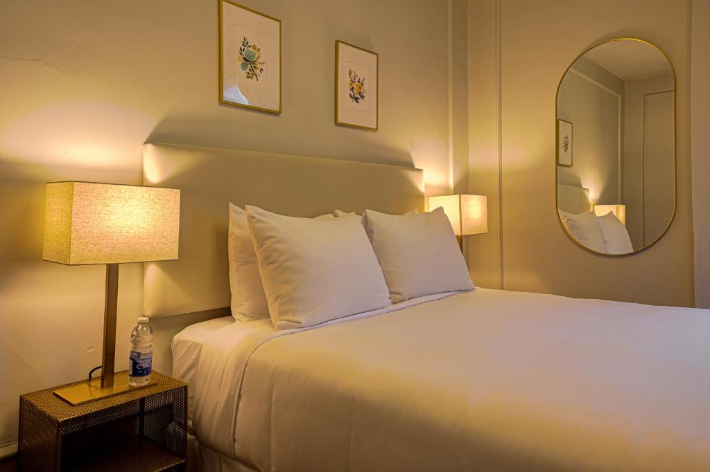 Pokój hotelowy z łóżkiem i lustrem w obiekcie The Windsor Hotel by Hoco Hotels Collection w mieście Stratford