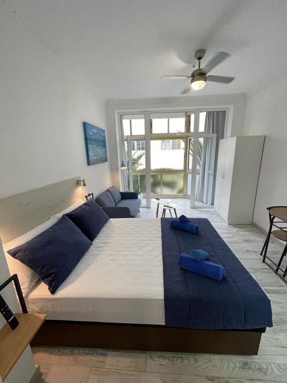 een slaapkamer met een groot bed met blauwe handdoeken bij PALMERAS 102 in Las Palmas de Gran Canaria