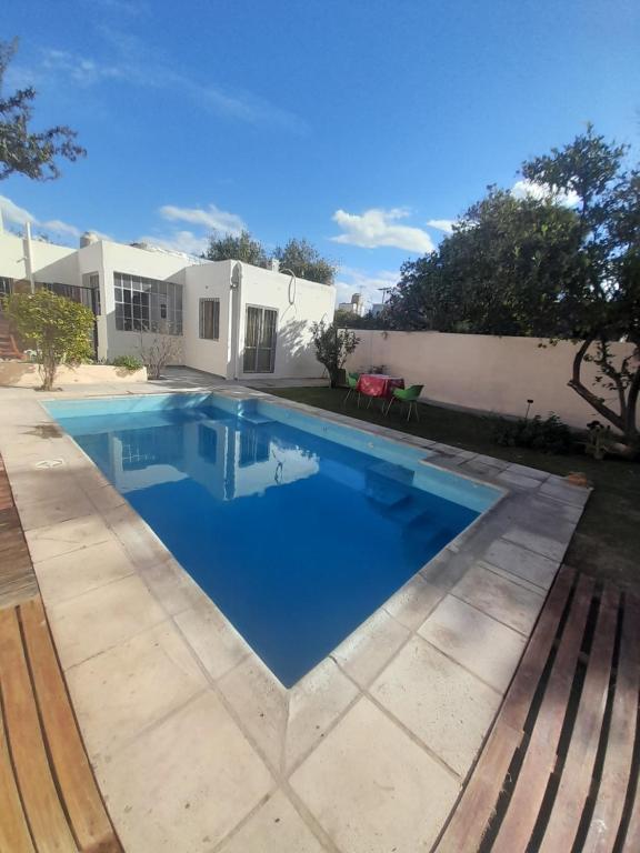 a swimming pool in front of a house at Casa con piscina y parrillero in San Juan