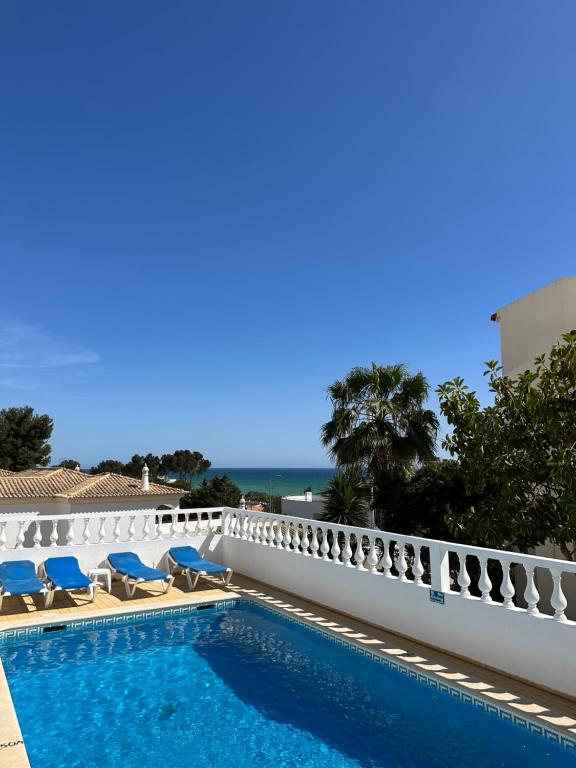 - une piscine avec des chaises et l'océan en arrière-plan dans l'établissement Vila Mar Central, à Albufeira