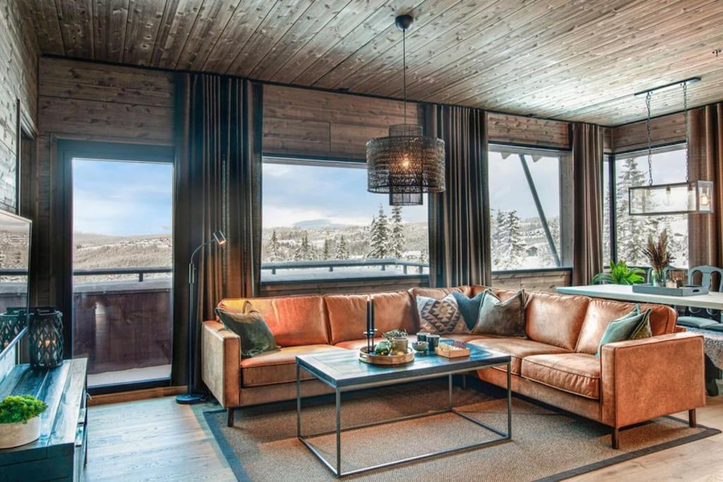 New ap The Nest in Hafjell ski in out and fast Wifi في أُيار: غرفة معيشة مع أريكة وطاولة