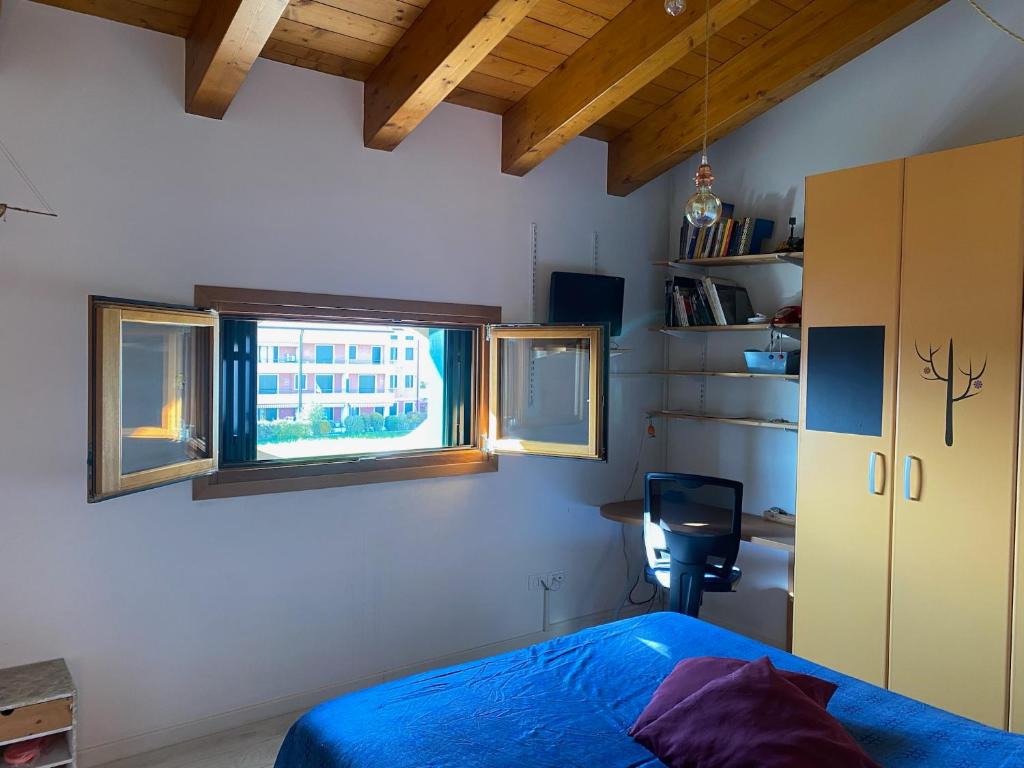 a bedroom with a blue bed and a window at fabio strano in Spresiano