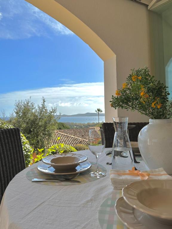 une table avec des assiettes et des verres à vin sur un balcon dans l'établissement Appartement Bastide Le Moulin, à Grimaud