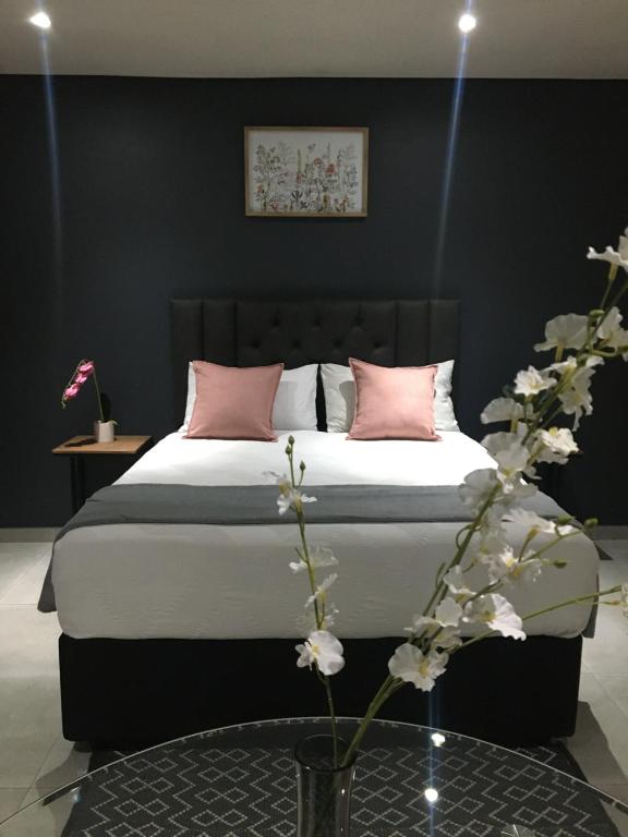sypialnia z dużym łóżkiem z różowymi poduszkami w obiekcie Black Rose Guesthouse w mieście Soweto