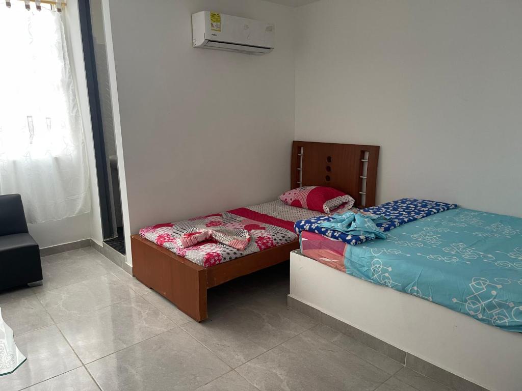 1 Schlafzimmer mit 2 Einzelbetten und einem Fenster in der Unterkunft Américas al límite in Cúcuta