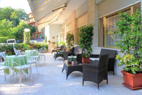 un patio al aire libre con mesas, sillas y plantas en PARK HOTEL, en Chianciano Terme