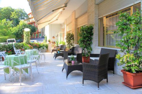 an outdoor patio with tables and chairs and plants at PARK HOTEL in Chianciano Terme