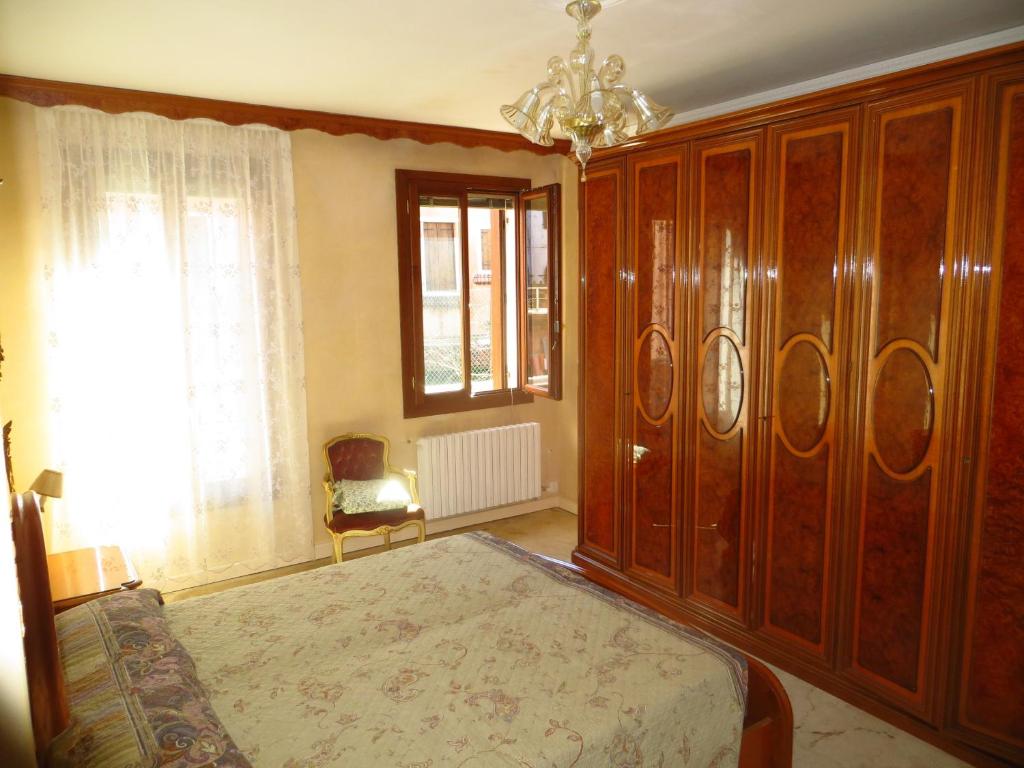 a bedroom with a bed and a large wooden cabinet at Asteria Venetian Suite in Venice