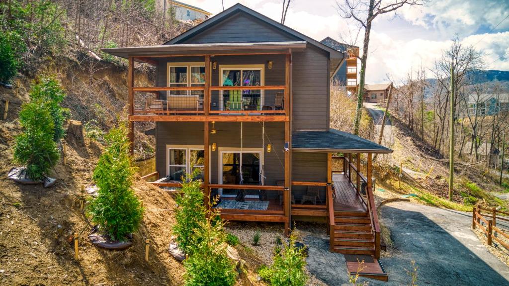a house on the side of a hill at Mins to Gburg Sleeps 8 Hot Tub Arcade Area Pool in Gatlinburg
