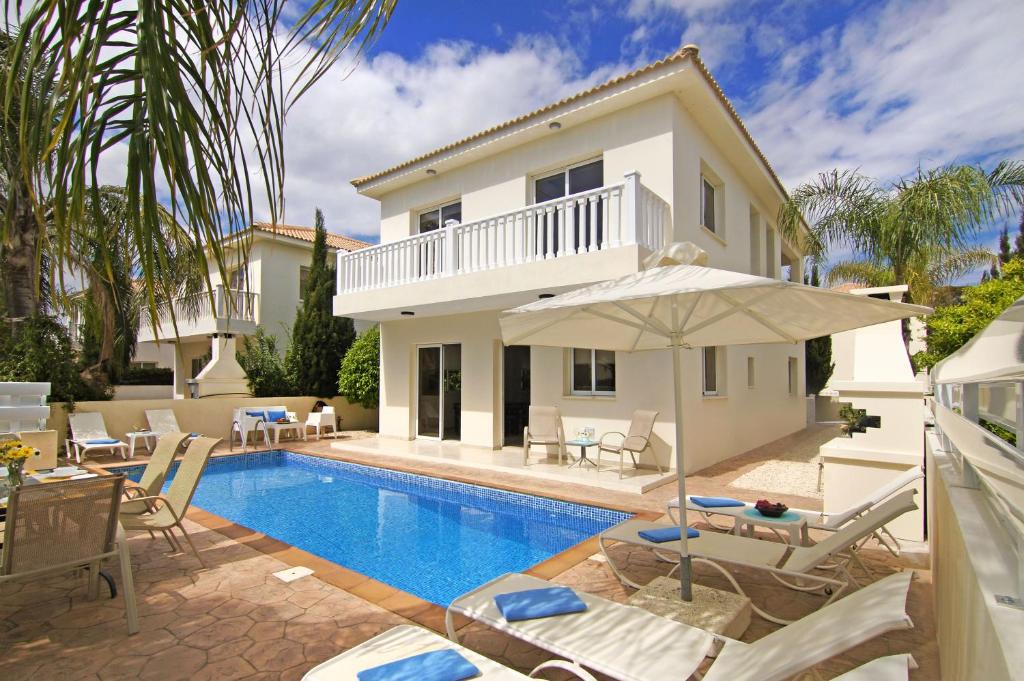 a villa with a swimming pool and a house at Nissi Sapphire Villa in Ayia Napa