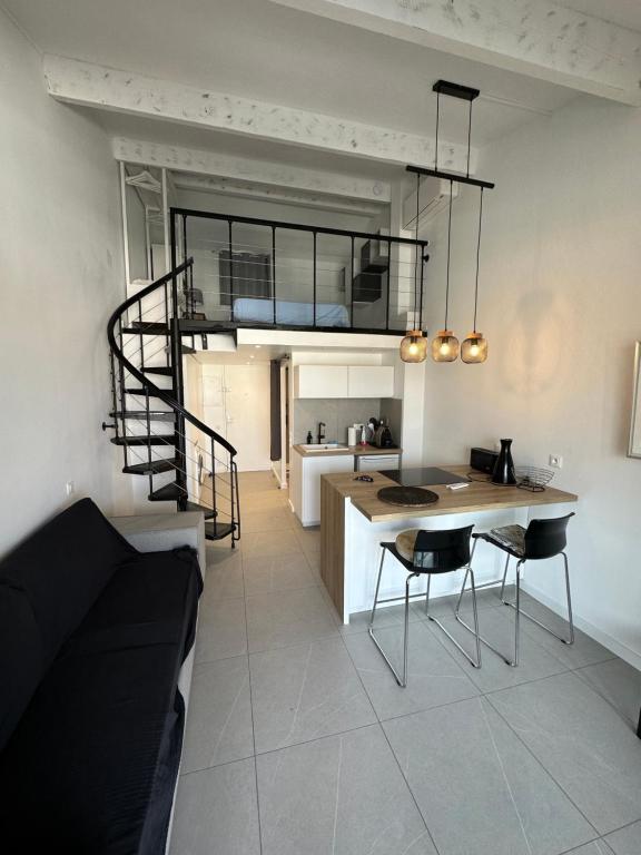 uma cozinha com uma cama alta, uma mesa e cadeiras em Appartement comptemporain vue mer em Grimaud