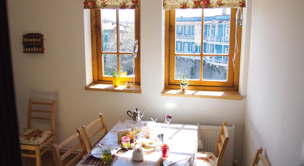 a dining room with a table and two windows at Pushkin 10 Hostel in Tbilisi City
