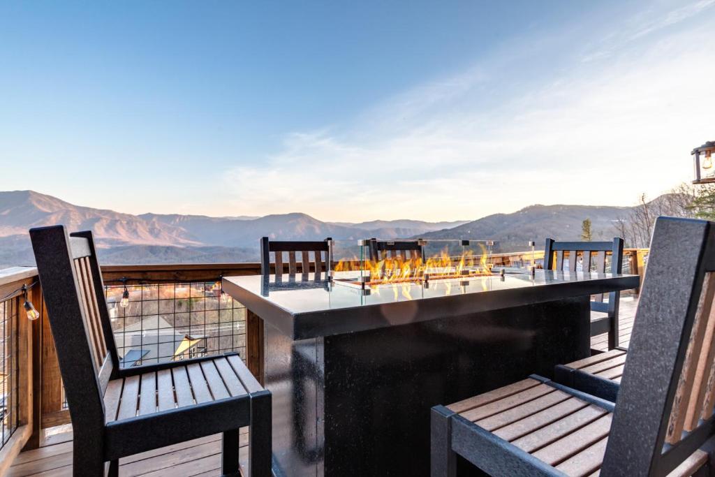 a deck with chairs and a table with a view of the mountains at Piney Estate Hot Tub Game Theater Room in Gatlinburg