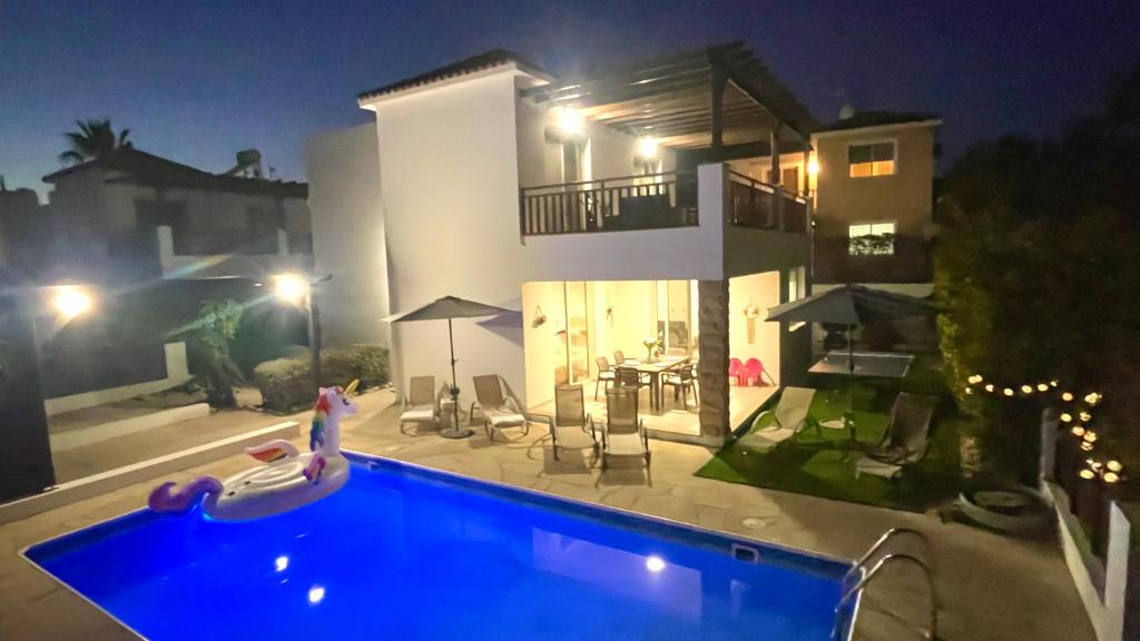 a swimming pool in front of a house at night at Villa Georgina & Villa Marianda Coral Bay in Coral Bay