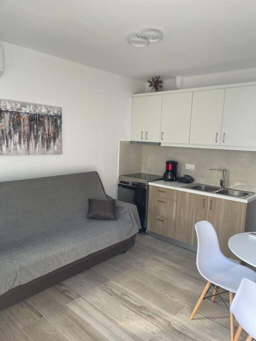 a living room with a couch and a kitchen at Enastron Cozy & Quiet Apartment in Heraklio