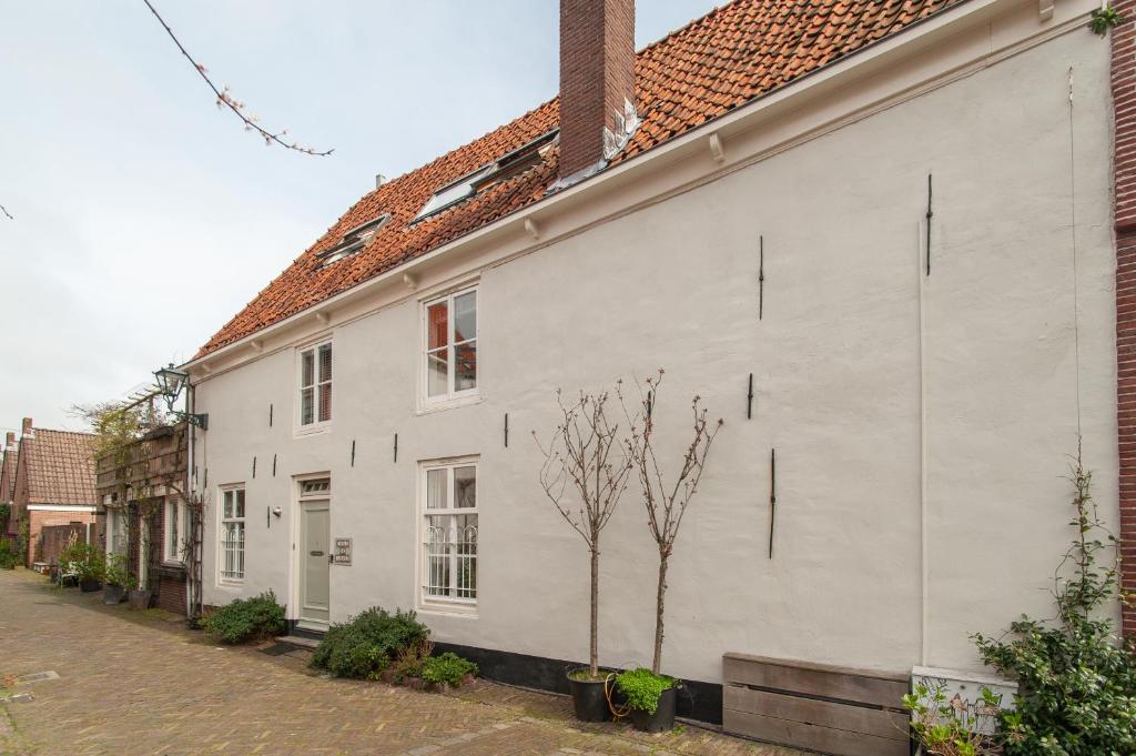 un edificio blanco con un árbol al lado de una calle en CASASdeCASPER - Apartment Alkmaar, en Alkmaar